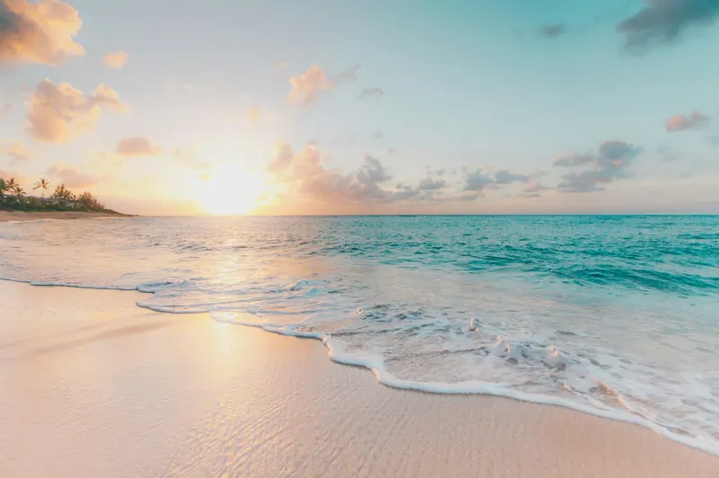 Waves rolling onto a sandy beach at sunrise