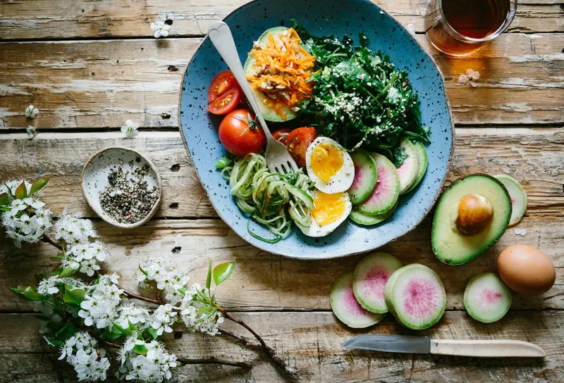 A colorful, healthy meal with vegetables, eggs, and avocado